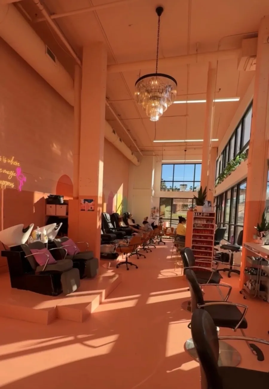 The 12 south salon in golden afternoon light, with a chandelier, shampoo bowls and pedicure chairs