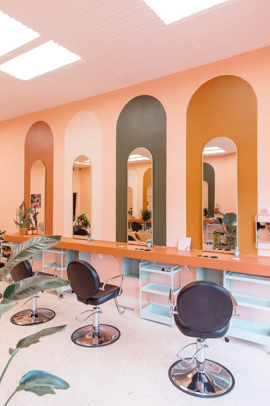 Tall green and mustard arch mirrors set into painted arches at goldfinch